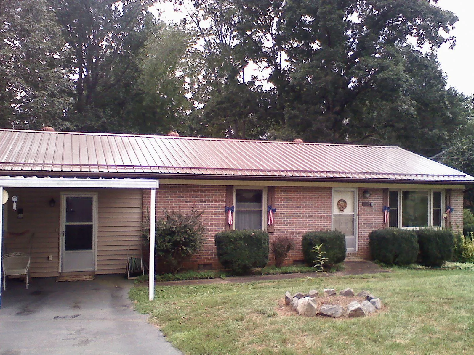 Bronze metal roof and carport on a brick ranch home — Roof Repair work by our crew in Weymouth